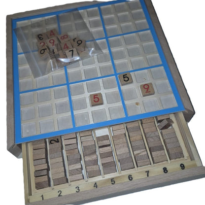 Wooden Sudoku board open with integrated drawer pulled out showing numbered wooden tiles sorted 1–9